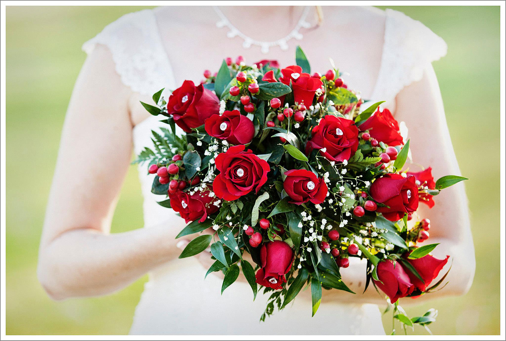 pale skinned bride holding bright red bouquet of flowers