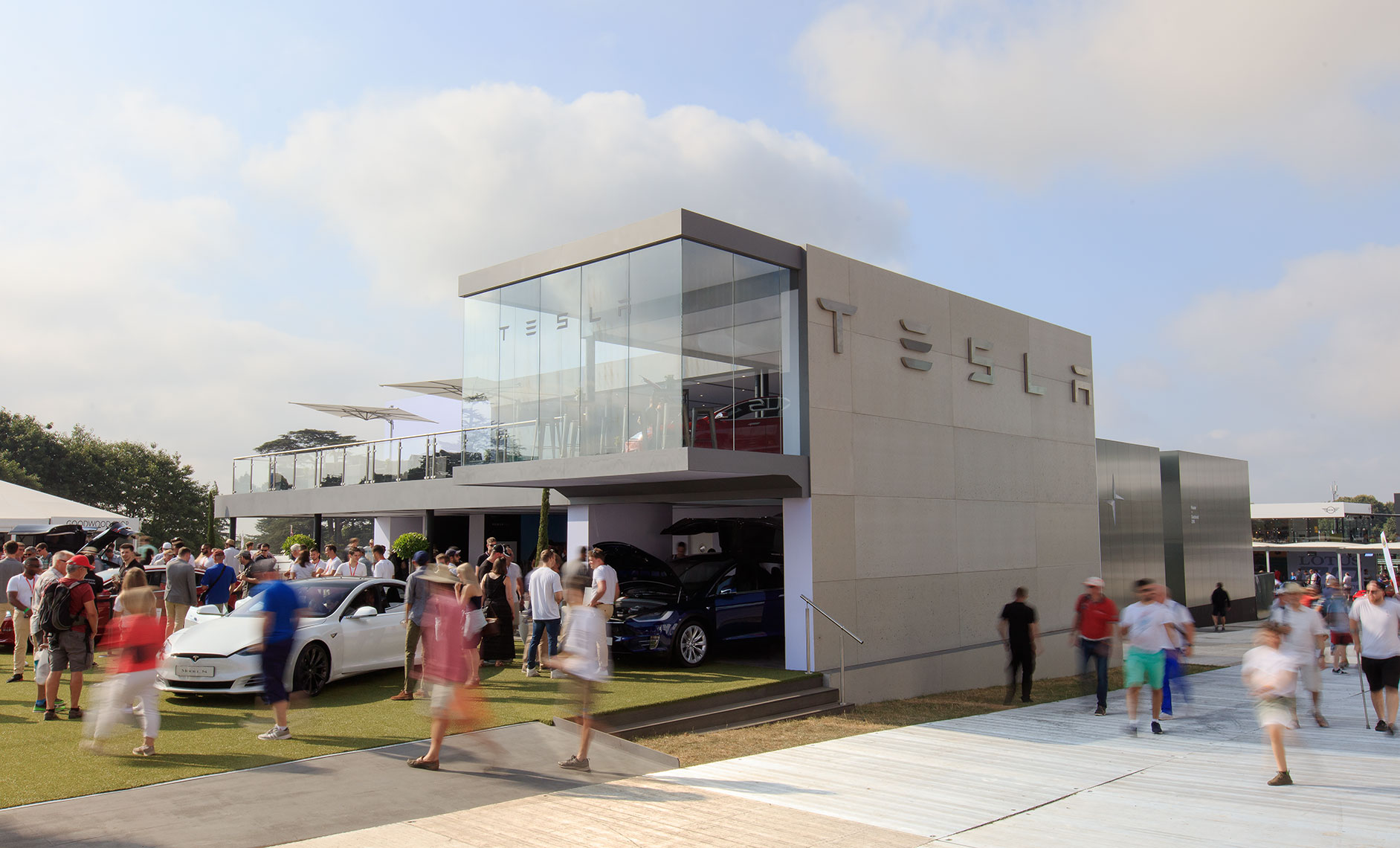 Tesla exhibition storefront being visited by customers at outdoor auto festival